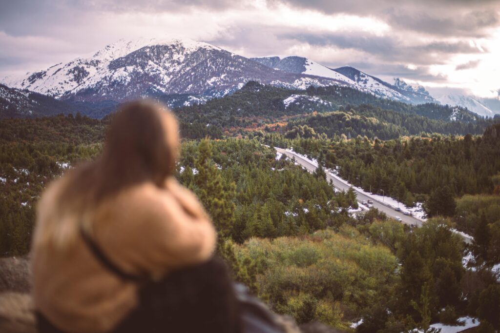A person enjoys the winter landscape view of Nahuel Huapi National Park in Bariloche, Argentina.
